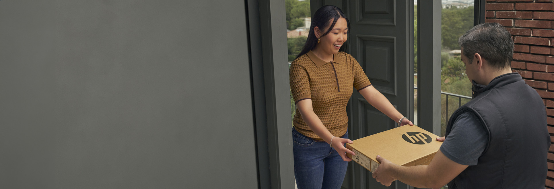 delivery man is passing a box to woman