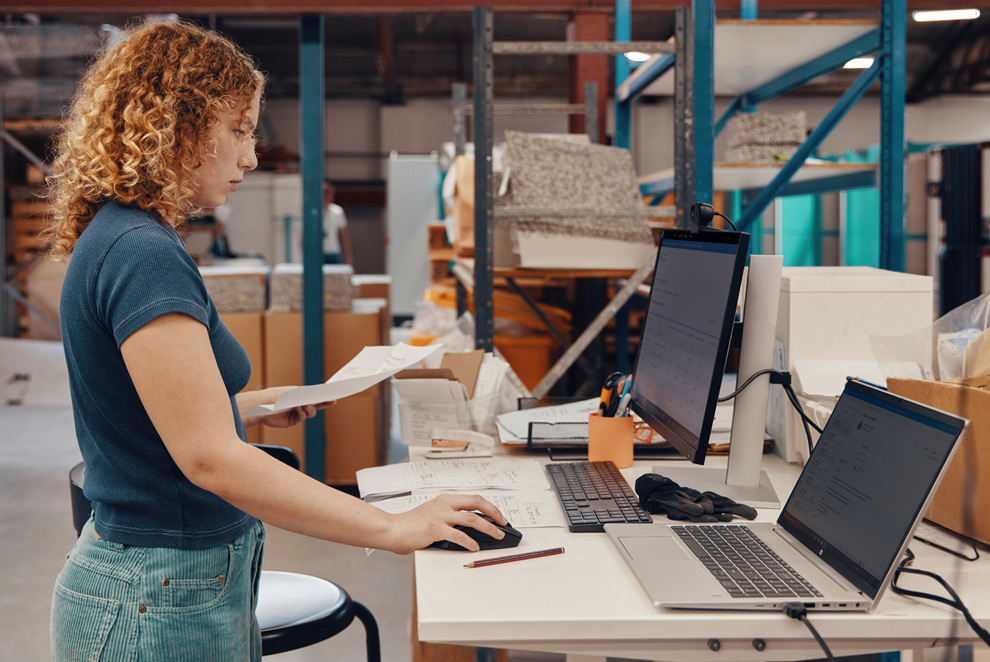 a woman working with a probook in a warehouse