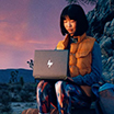 image of girl sitting outdoor and working with a hp laptop