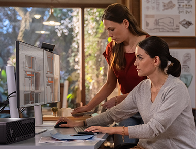 A person working on her HP desktop PC using dual HP monitors