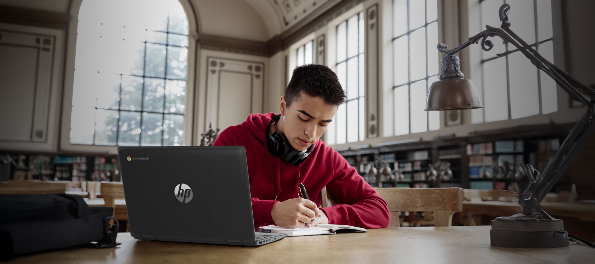 A man sitting at a table, focused on his laptop